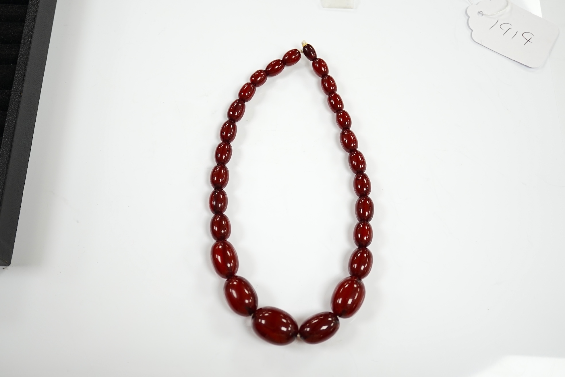 A single strand graduated oval simulated cherry amber bead necklace, 38cm, gross weight 41 grams. Condition - poor to fair